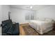 Bedroom featuring wood-look floors, ceiling fan, a futon, and a comfortable queen-sized bed at 12118 W Villa Chula Ct, Sun City, AZ 85373