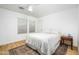 Neutral bedroom with ceiling fan, wood-look floors, area rug, and side table at 12118 W Villa Chula Ct, Sun City, AZ 85373