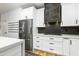 Stylish kitchen featuring stainless steel refrigerator, white cabinets, and herringbone backsplash at 12118 W Villa Chula Ct, Sun City, AZ 85373