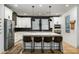 Modern kitchen with white cabinetry, stainless steel appliances, island with seating, and herringbone backsplash at 12118 W Villa Chula Ct, Sun City, AZ 85373