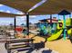 Community playground featuring a slide and other playground features, picnic tables, and covered seating area at 123 N 175Th Ave, Goodyear, AZ 85338