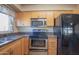 Close-up shot of kitchen area with wood cabinets, granite countertops, and stainless steel appliances at 13134 N 20Th Ave, Phoenix, AZ 85029