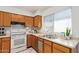 Charming kitchen features wood cabinets, white appliances, and a bright window overlooking the sink at 14224 N 26Th Ln, Phoenix, AZ 85023