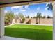 Backyard featuring artificial grass, rock landscaping, and a block fence at 14425 N 137Th Ln, Surprise, AZ 85379