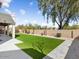 Large backyard with artifical grass, rock features, and a large shade tree at 14425 N 137Th Ln, Surprise, AZ 85379