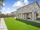 Exterior view of the house showing a well-kept backyard with artificial grass and a patio at 14425 N 137Th Ln, Surprise, AZ 85379