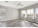 Bright bedroom featuring wood-look floors, a ceiling fan, and multiple windows for ample natural light at 14425 N 137Th Ln, Surprise, AZ 85379