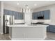 Modern kitchen with an island, stainless steel appliances, sleek blue cabinets, and beautiful countertops at 14425 N 137Th Ln, Surprise, AZ 85379