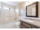 Bathroom with shower over tub, white marble and dark framed mirror at 14510 W Yosemite Dr, Sun City West, AZ 85375