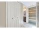 Hallway with view to bathroom and closet with shelves at 14510 W Yosemite Dr, Sun City West, AZ 85375