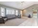 Bright living room with carpet and tile flooring, featuring large windows and a ceiling fan at 14510 W Yosemite Dr, Sun City West, AZ 85375