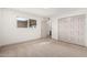 Bedroom featuring neutral carpet and trim, with an outside view through a window and closet space at 1517 E Dunbar Dr, Tempe, AZ 85282