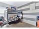 Bright bedroom with a bunk bed, striped accent wall, and carpet flooring at 1565 W Plana Ave, Mesa, AZ 85202