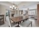 Well-lit dining room featuring a chandelier, an expansive wooden table, and comfortable seating at 1565 W Plana Ave, Mesa, AZ 85202