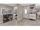 Bright entrance hall with tile flooring, a decorative front door and coat rack featuring built-in storage at 1565 W Plana Ave, Mesa, AZ 85202