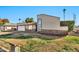 Low angle view of front exterior displaying desert landscaping, palm trees and an attached two-car garage at 1565 W Plana Ave, Mesa, AZ 85202