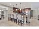 Kitchen island with barstool seating that features dark wood cabinets and stainless appliances at 1565 W Plana Ave, Mesa, AZ 85202