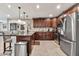 Spacious kitchen with a granite island, dark wood cabinets, and stainless steel appliances for modern living at 1565 W Plana Ave, Mesa, AZ 85202