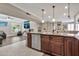 Kitchen island sink with stylish brown cabinetry and modern fixtures, adjacent to a cozy living space at 1565 W Plana Ave, Mesa, AZ 85202