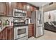 Updated kitchen featuring stainless steel appliances, a tile backsplash, and beautiful wood cabinetry at 1565 W Plana Ave, Mesa, AZ 85202