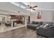 Open-concept living room with a ceiling fan, modern decor and connecting to a kitchen with stainless steel appliances at 1565 W Plana Ave, Mesa, AZ 85202