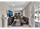 Relaxing living room featuring tile floors, white doors, desk setup, and large TV at 1565 W Plana Ave, Mesa, AZ 85202