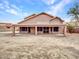 Rear view of house with covered patio, block wall, and neutral stucco at 15819 W Ripple Rd, Goodyear, AZ 85338