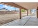 Spacious backyard featuring a covered patio with concrete flooring, a large grassy area, and brick walls at 15819 W Ripple Rd, Goodyear, AZ 85338