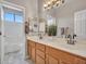 Bathroom featuring a double sink vanity, mirror, and a well-lit tub and shower at 15819 W Ripple Rd, Goodyear, AZ 85338