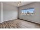 Bedroom with a ceiling fan, wood flooring, and window overlooking a neighborhood at 15819 W Ripple Rd, Goodyear, AZ 85338