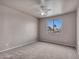 Bedroom with a ceiling fan, carpet, and window view with palm trees at 15819 W Ripple Rd, Goodyear, AZ 85338