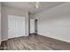 Bedroom featuring wood flooring, a ceiling fan, closet doors, and an attached bathroom at 15819 W Ripple Rd, Goodyear, AZ 85338