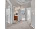 Carpeted hallway showcasing access to multiple rooms, including a bathroom and a bedroom with natural light at 15819 W Ripple Rd, Goodyear, AZ 85338