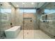 Bright bathroom features gray marble tiling, a glass shower, and large soaking tub at 16908 S 31St Ln, Phoenix, AZ 85045