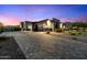 Paver driveway leading to a modern home with three-car garage and desert landscaping at twilight at 16908 S 31St Ln, Phoenix, AZ 85045