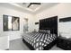 Chic bedroom with a black and white geometric bedspread, a black headboard, and a large window at 16908 S 31St Ln, Phoenix, AZ 85045