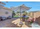 Serene backyard retreat features a blue and white striped umbrella, comfortable seating, and well-manicured landscaping at 17210 N Firestone Ln, Surprise, AZ 85374