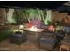 Inviting backyard patio with comfortable seating, firepit and beautiful landscaping, perfect for nighttime relaxation at 17210 N Firestone Ln, Surprise, AZ 85374