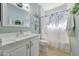 Bathroom features vanity with white marble countertop and a shower with a floral shower curtain at 17210 N Firestone Ln, Surprise, AZ 85374