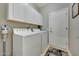 Laundry room with white washer and dryer, storage cabinets, and neutral paint at 17210 N Firestone Ln, Surprise, AZ 85374