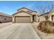 Tan two-story home featuring a large front-facing garage and desert landscaping at 1726 E Cortez Dr, Casa Grande, AZ 85122