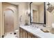 Stylish bathroom with a marble countertop, wooden cabinets, and a walk-in shower at 18683 N 101St Pl, Scottsdale, AZ 85255