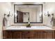 Double-sink bathroom vanity with stone countertops, stylish fixtures, and an oversized mirror at 18683 N 101St Pl, Scottsdale, AZ 85255