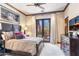 Cozy bedroom with a dark wood bed frame, plush bedding, and natural light from a French door at 18683 N 101St Pl, Scottsdale, AZ 85255