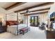 Spacious bedroom featuring exposed wood beams, a four-poster bed, and a patio view at 18683 N 101St Pl, Scottsdale, AZ 85255