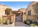 Inviting gated courtyard entrance with blooming bougainvillea and decorative potted cacti at 18683 N 101St Pl, Scottsdale, AZ 85255