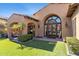 Beautiful home exterior with arched doorway, manicured lawn, and charming architectural details at 18683 N 101St Pl, Scottsdale, AZ 85255