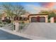 Charming home exterior with a paver driveway, mature desert landscaping, and a two-car garage at 18683 N 101St Pl, Scottsdale, AZ 85255