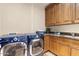 Well-equipped laundry room featuring a front-load washer and dryer, with countertops for folding and storage at 18683 N 101St Pl, Scottsdale, AZ 85255