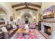 Open concept living room with a stone fireplace, beamed ceilings, hardwood floors and stylish furniture at 18683 N 101St Pl, Scottsdale, AZ 85255